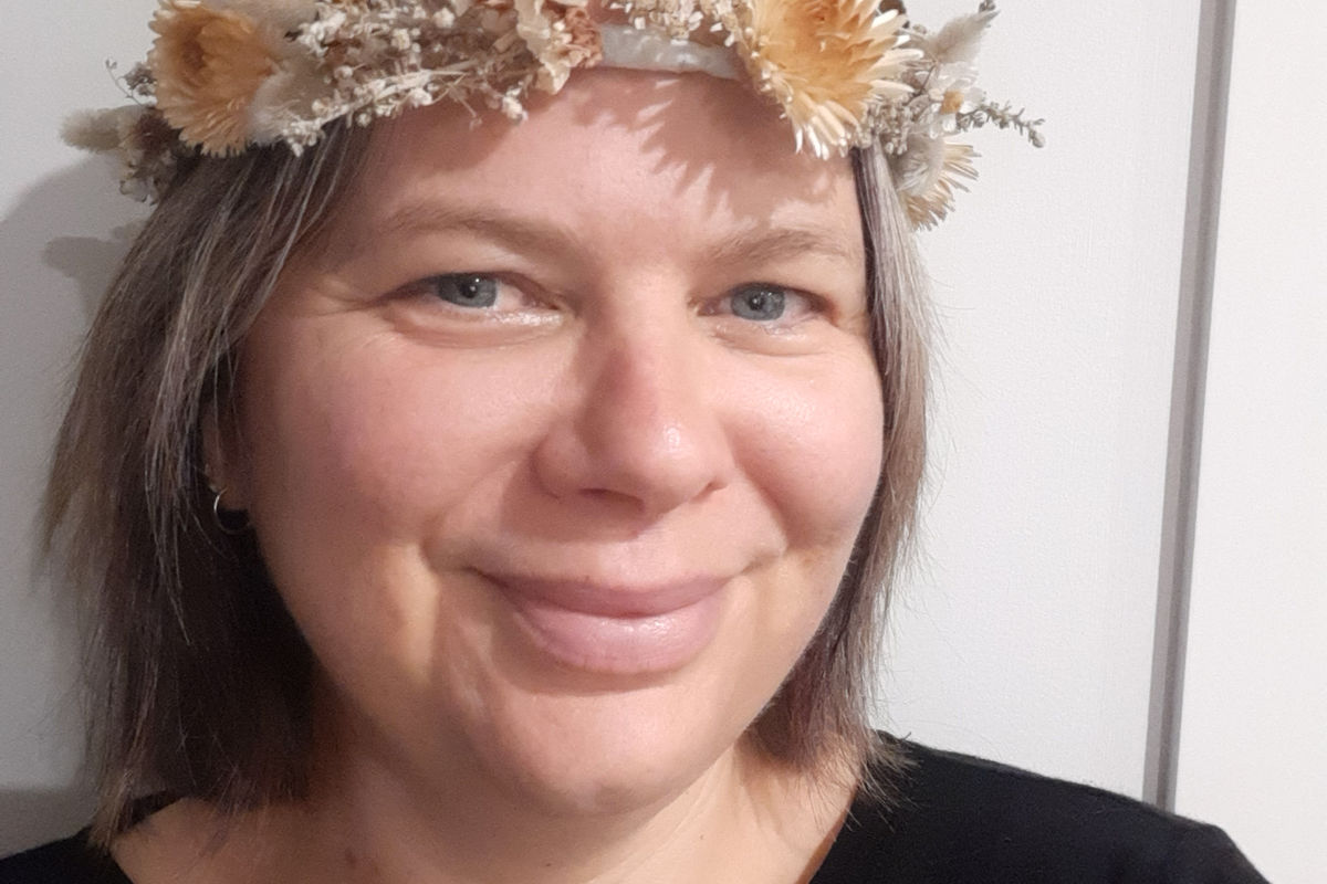 Portrait of writer Helena Harvey wearing a flower crown.